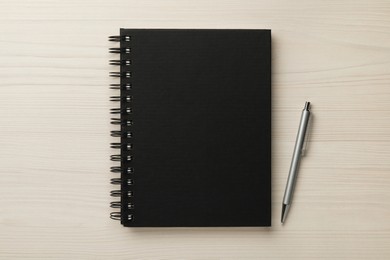 Notebook and pen on white wooden table, flat lay