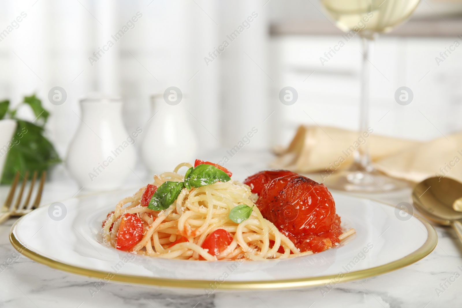 Photo of Tasty pasta with tomatoes, cheese and basil on white marble table