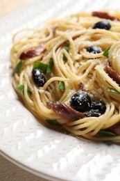 Photo of Delicious pasta with anchovies, olives and parmesan cheese on table, closeup