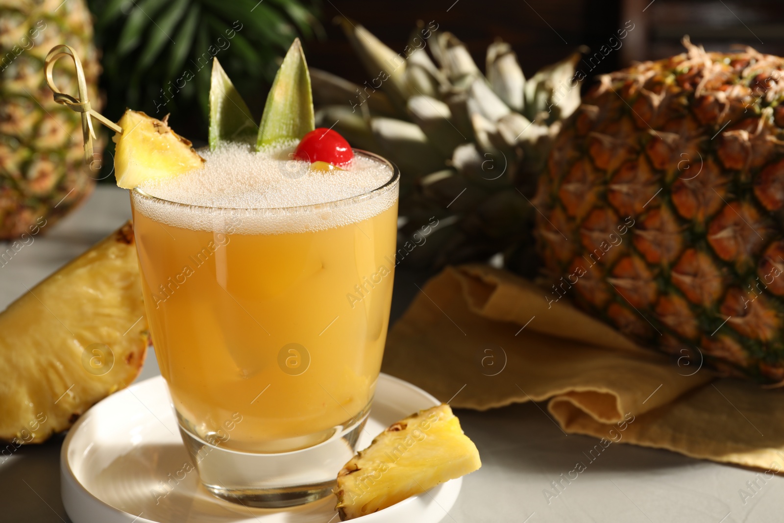 Photo of Tasty pineapple cocktail and fresh fruit on light grey table. Space for text