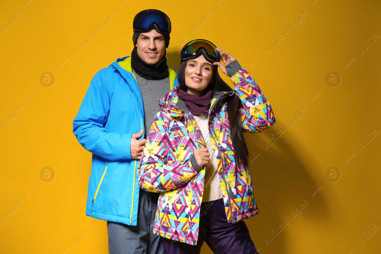 Photo of Couple wearing stylish winter sport clothes on yellow background