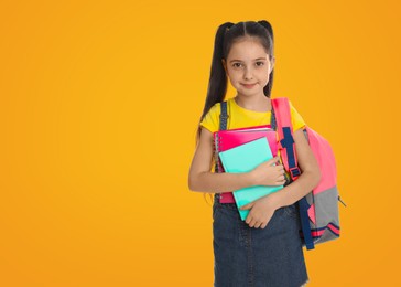 Image of Little girl with school stationery on yellow background, space for text