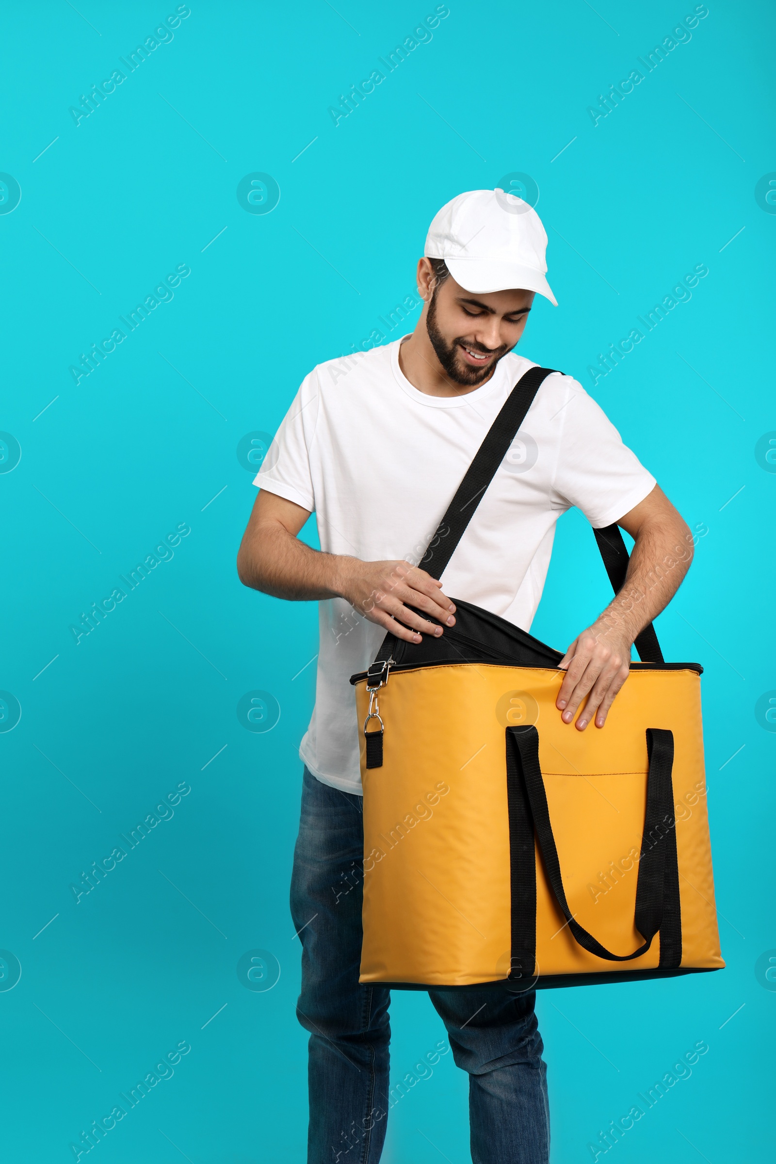 Photo of Young courier with thermo bag on color background. Food delivery service