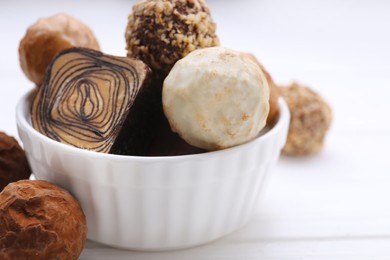 Photo of Tasty chocolate candies on white wooden table, closeup