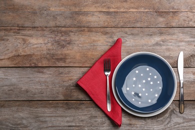 Photo of Patriotic table setting with traditional USA colors on wooden background, flat lay. Space for text