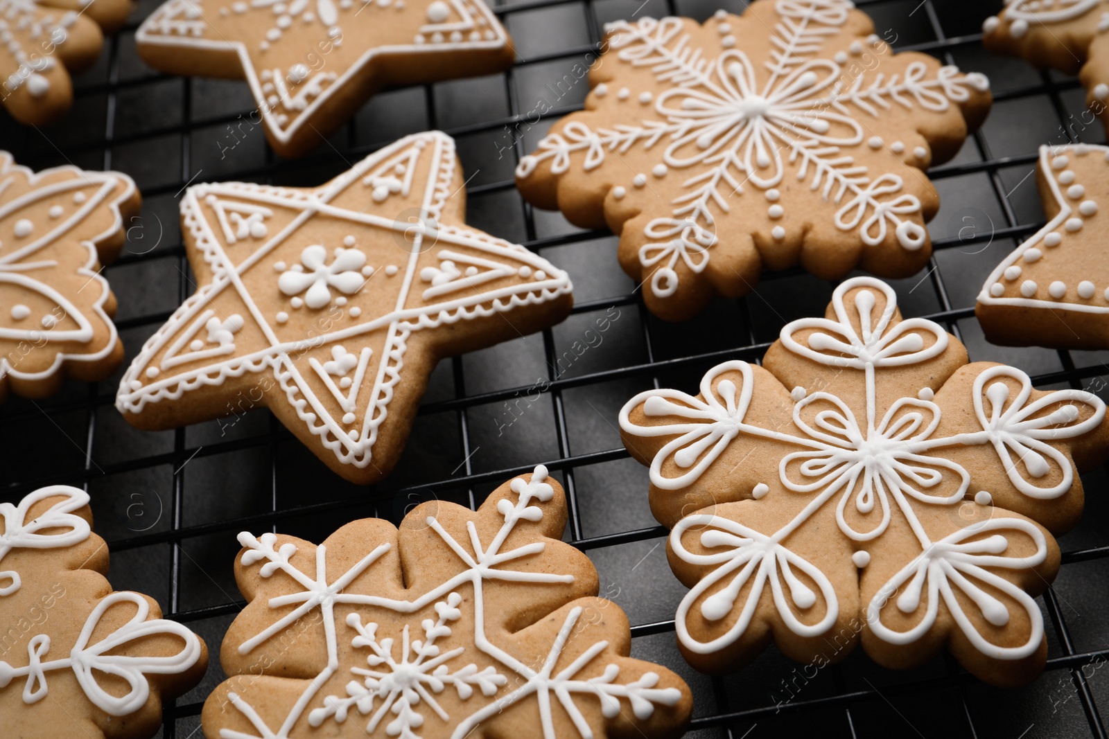 Photo of Tasty Christmas cookies on cooling rack, closeup