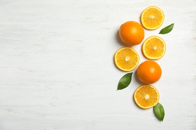 Photo of Flat lay composition with fresh oranges on wooden table. Space for text