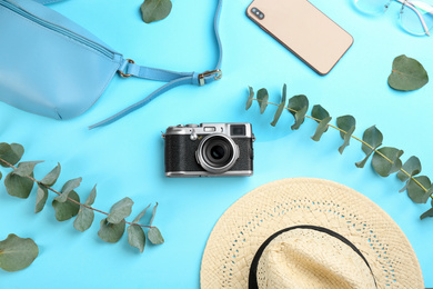 Flat lay composition with camera for professional photographer on light blue background