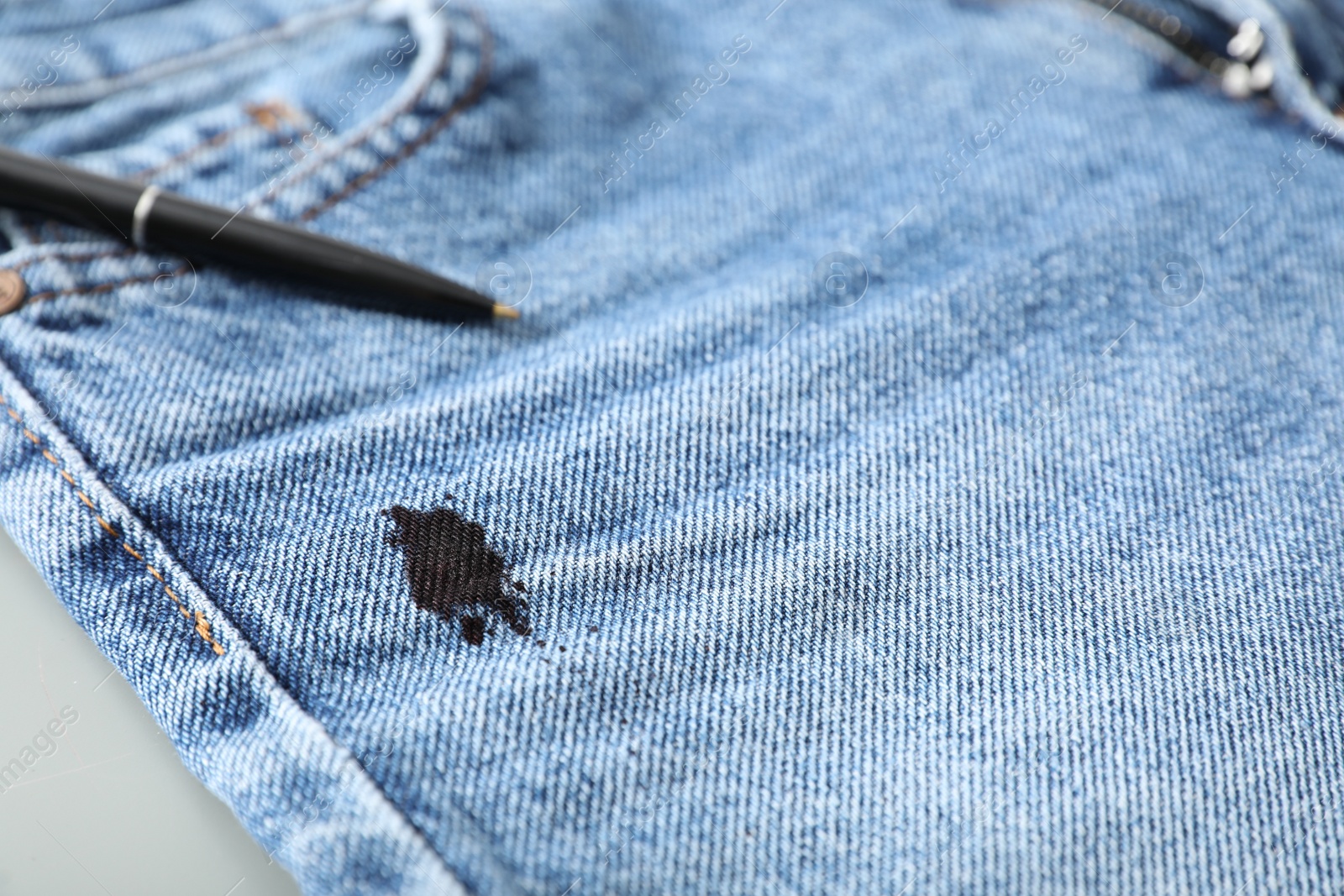 Photo of Pen and stain of black ink on jeans, closeup. Space for text