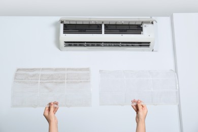 Woman holding air conditioner filters indoors, closeup