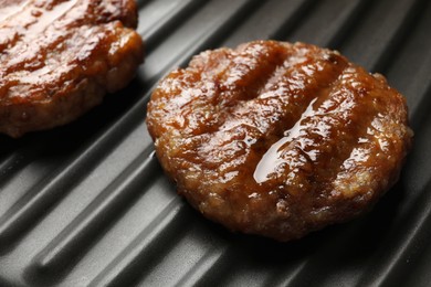 Delicious hamburger patties on electric grill, closeup
