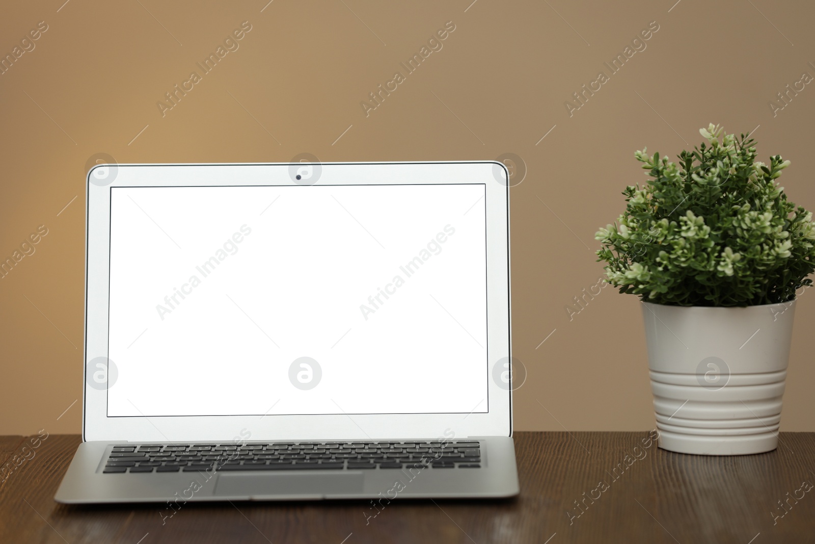 Photo of Laptop with blank screen on table indoors. Space for text