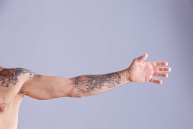 Photo of Tattooed man on grey background, closeup of arm
