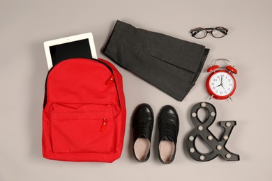 Composition with school uniform for girl on grey background, top view