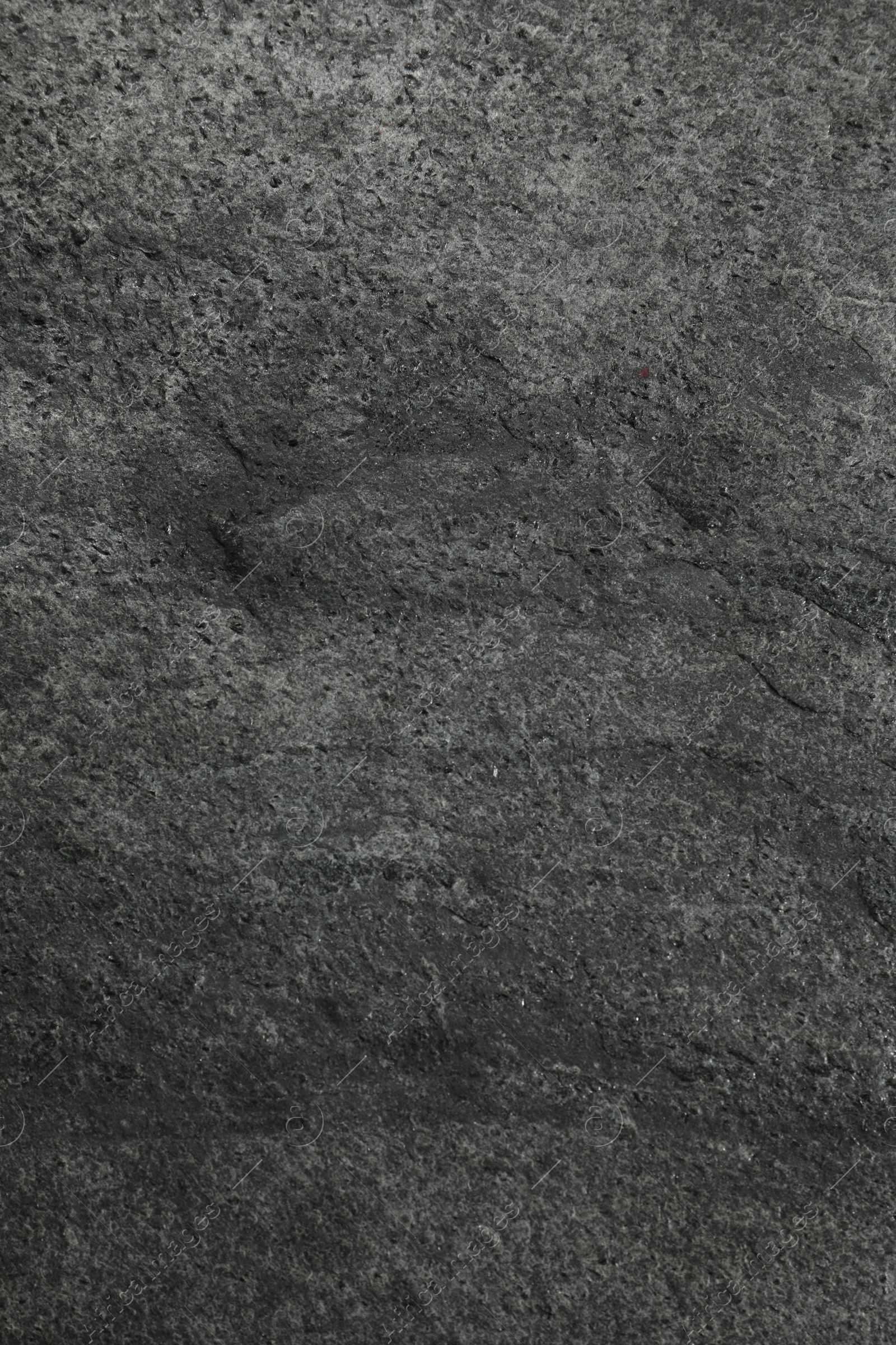 Photo of Texture of dark grey stone surface as background, closeup