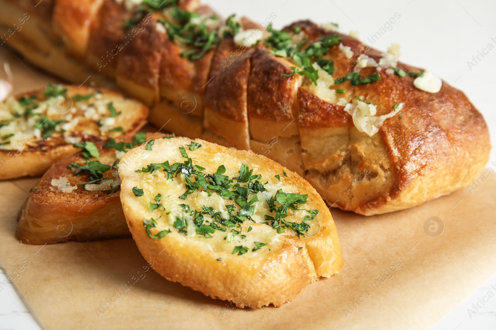 Photo of Delicious homemade garlic bread with herbs on table