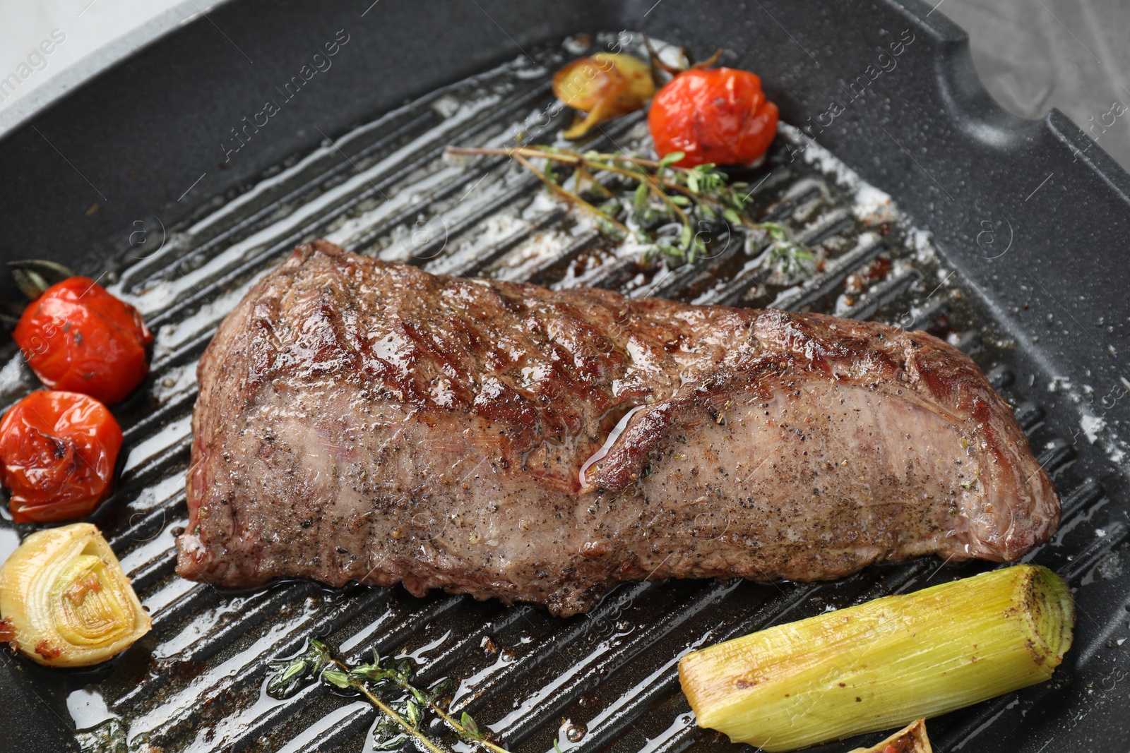 Photo of Delicious grilled beef meat and vegetables in pan, closeup