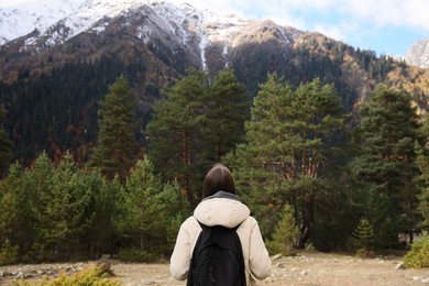 Photo of Woman with backpack in beautiful mountains, back view