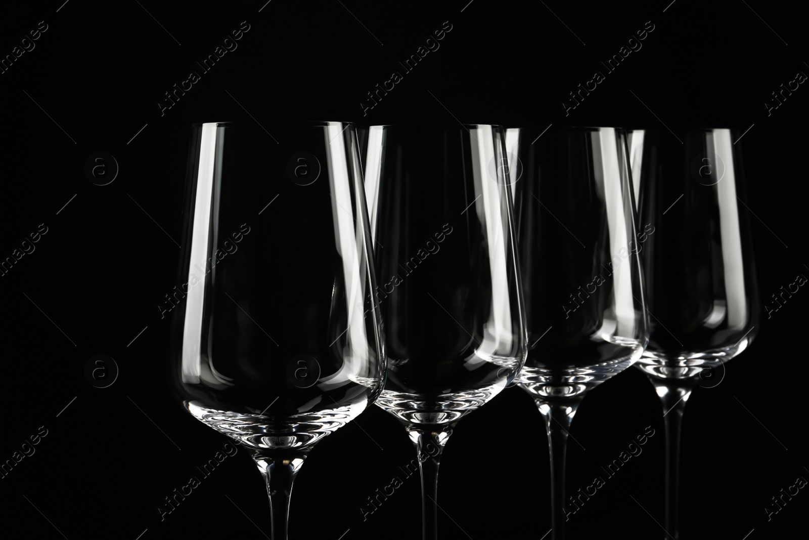 Photo of Set of empty wine glasses on black background