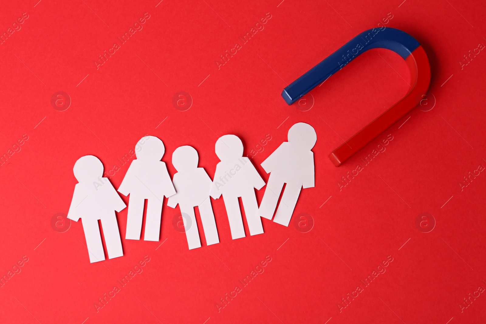 Photo of Magnet and paper people on red background, flat lay