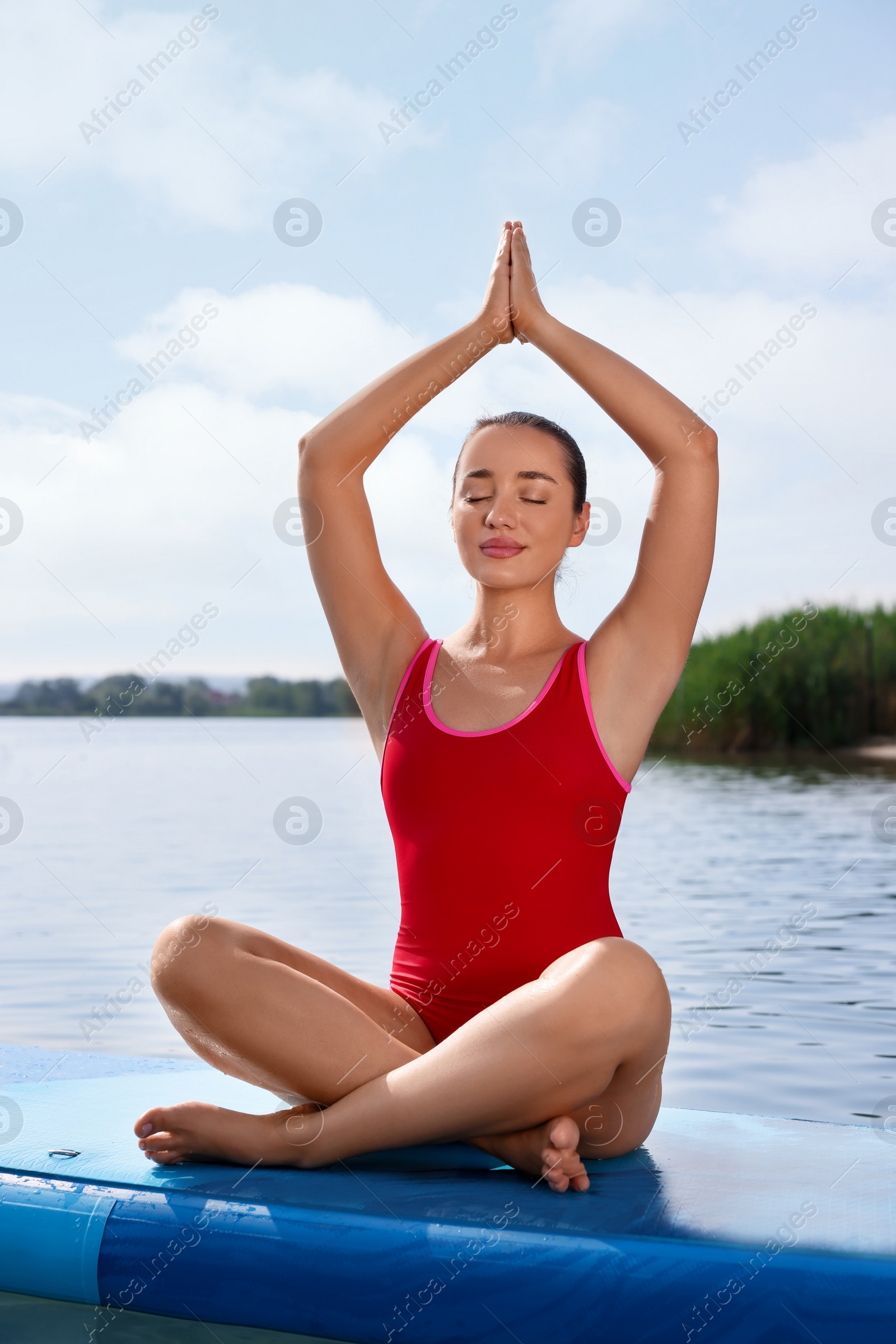 Photo of Woman practicing yoga on light blue SUP board on river