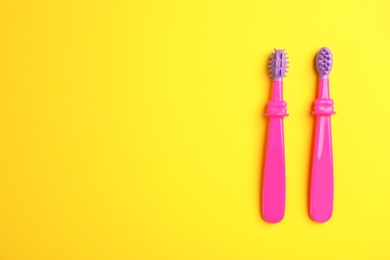 Photo of Manual toothbrushes for children on color background, top view with space for text