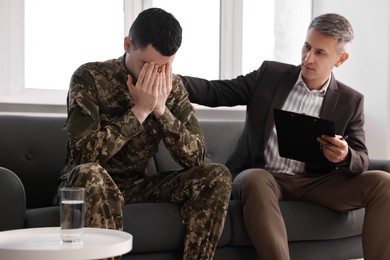 Professional psychotherapist working with military man in office