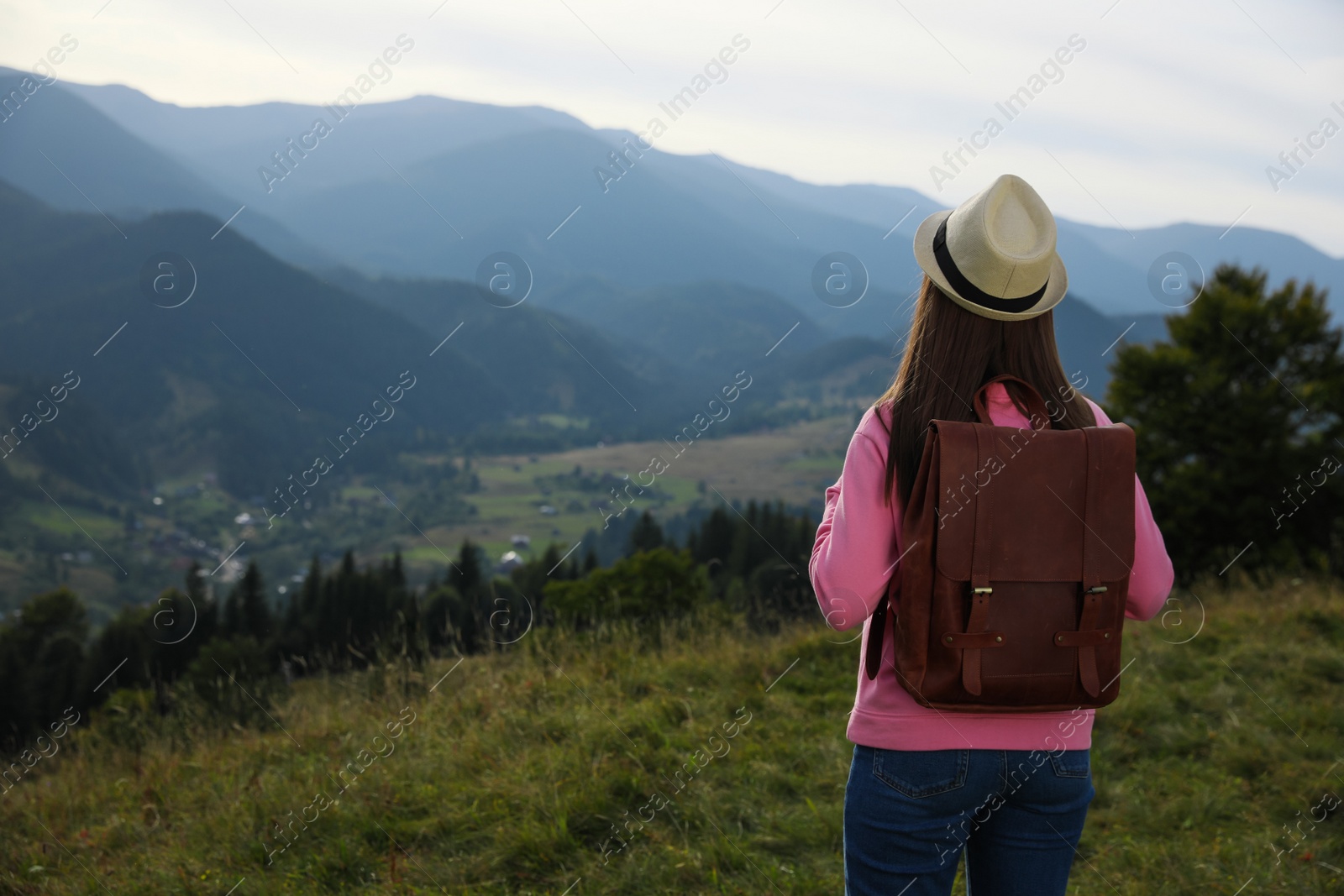 Photo of Woman enjoying mountain landscape, back view. Space for text