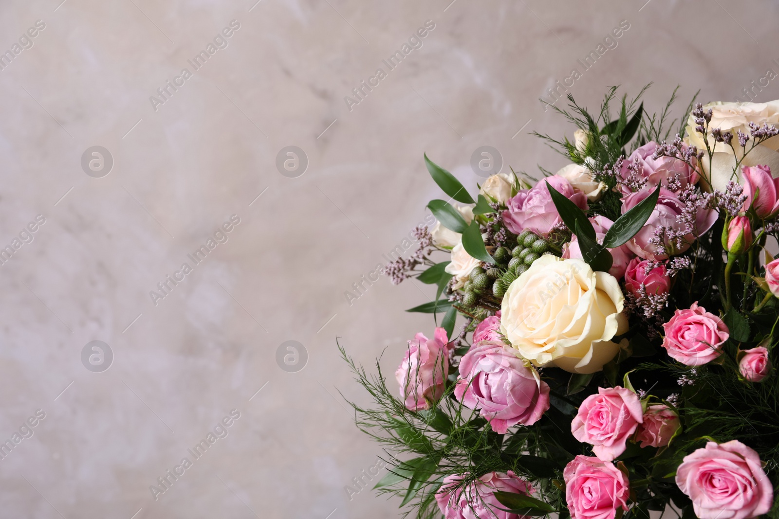 Photo of Beautiful bouquet with roses on beige background, closeup. Space for text