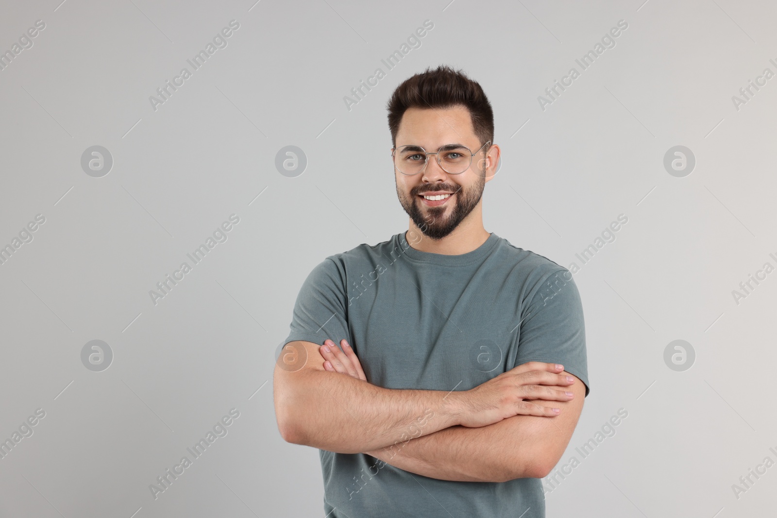 Photo of Handsome man wearing glasses on light gray background, space for text