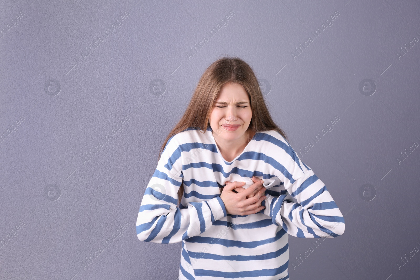 Photo of Young woman having heart attack on color background