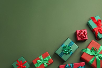 Photo of Many gift boxes on dark green background, flat lay. Space for text