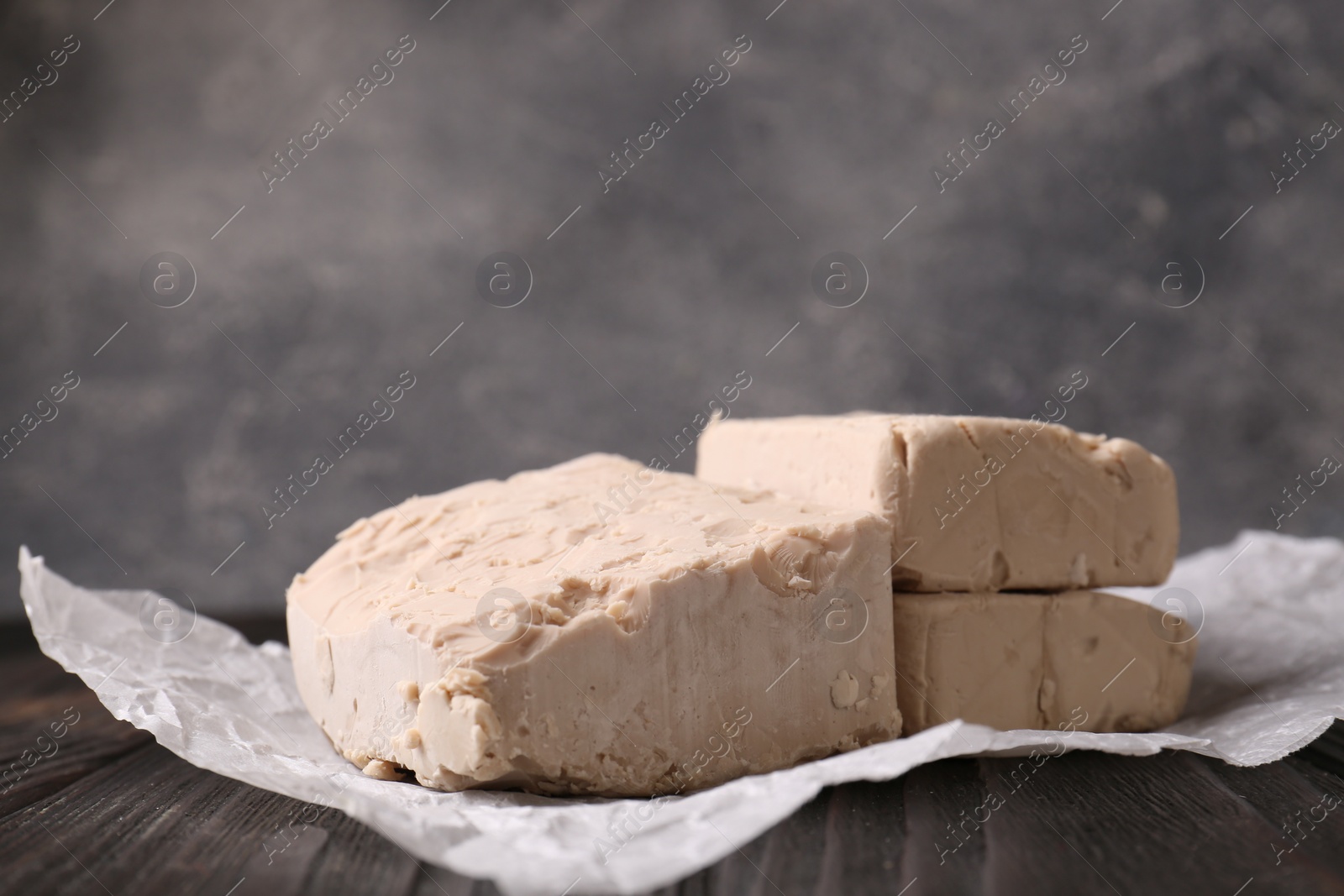 Photo of Closeup view of compressed yeast on wooden table