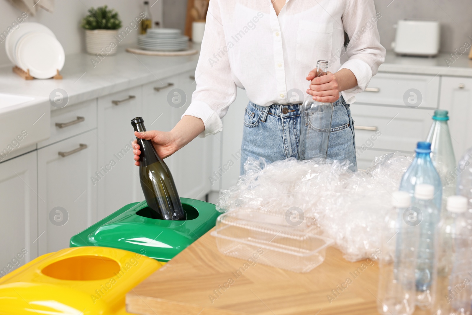 Photo of Woman separating garbage at table indoors, closeup