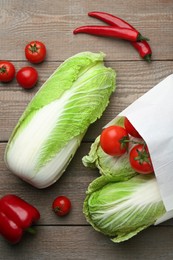 Fresh Chinese cabbages, tomatoes and peppers on wooden table, flat lay