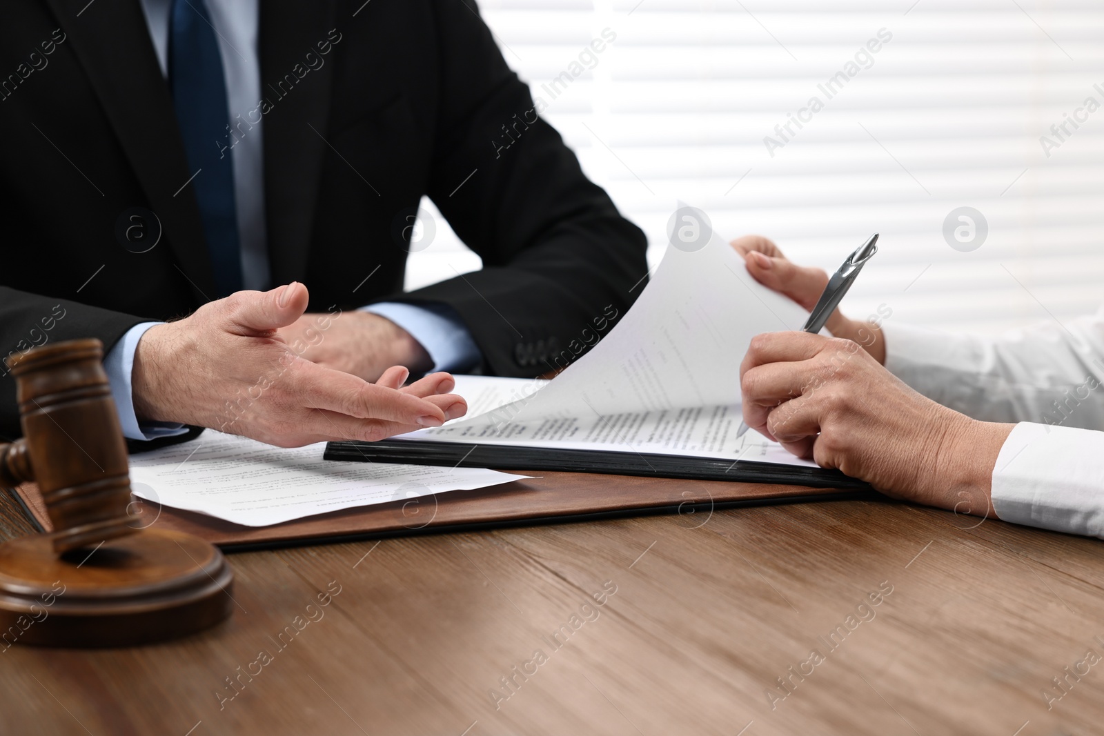 Photo of Senior woman signing document in lawyer's office, closeup