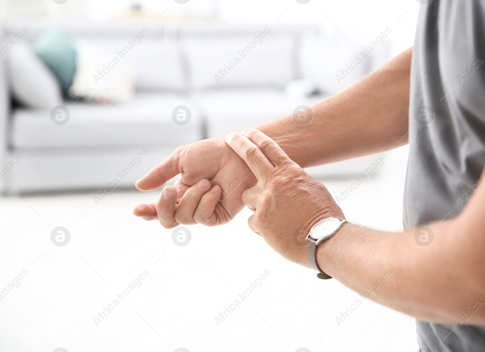 Photo of Senior man checking pulse on blurred background