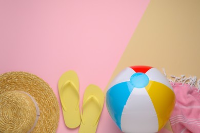 Photo of Colorful beach ball, hat, blanket and flip flops on color background, flat lay. Space for text