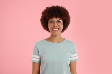 Portrait of happy young woman on pink background