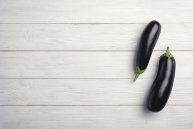 Photo of Raw ripe eggplants on wooden background, top view