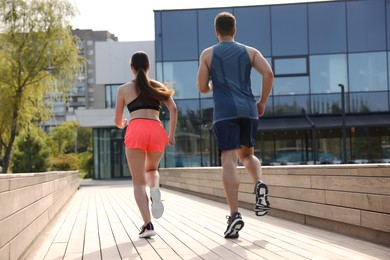 Photo of Healthy lifestyle. Couple running outdoors on sunny day, low angle view