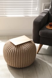 Laptop on stylish comfortable pouf in room. Home design
