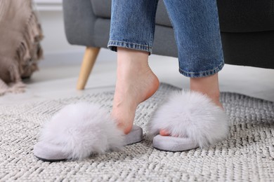 Woman in fluffy slippers at home, closeup