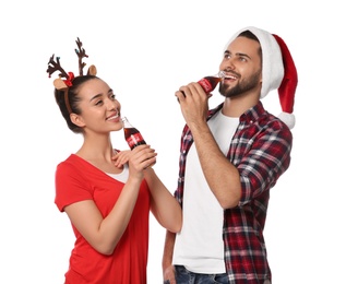 MYKOLAIV, UKRAINE - JANUARY 27, 2021: Young couple drinking Coca-Cola on white background. Christmas atmosphere