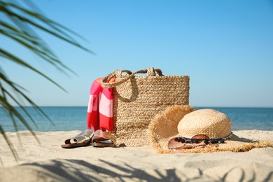 Photo of Stylish beach accessories on sandy sea shore