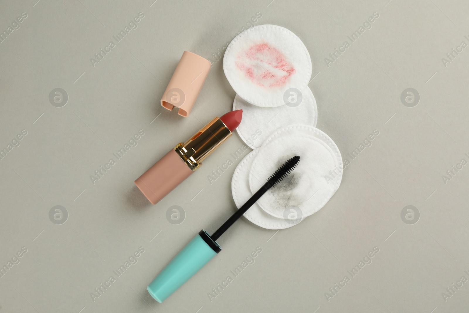Photo of Clean and dirty cotton pads, lipstick with mascara on light background, flat lay