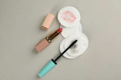 Clean and dirty cotton pads, lipstick with mascara on light background, flat lay