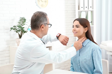 Photo of Doctor checking young woman's pulse with fingers in hospital