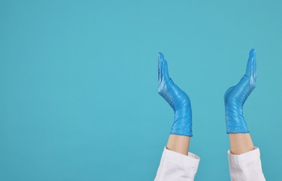 Photo of Doctor holding something on light blue background, closeup. Space for text