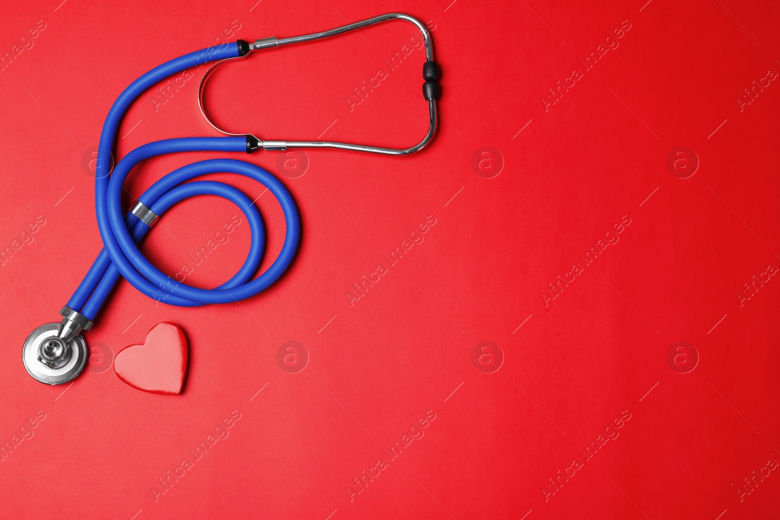 Photo of Stethoscope with heart on color background, flat lay